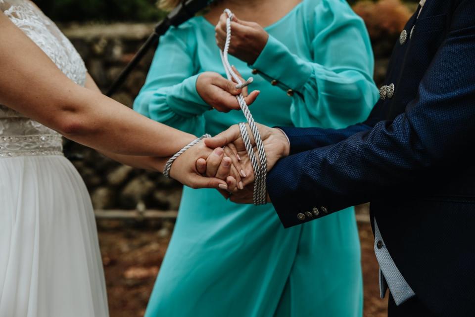 Tying the knot – literally. <a href="https://www.gettyimages.com/detail/photo/traditional-handfasting-ceremony-during-the-wedding-royalty-free-image/1438085024?phrase=wedding+vows&adppopup=true" rel="nofollow noopener" target="_blank" data-ylk="slk:Wirestock/iStock via Getty Images Plus;elm:context_link;itc:0;sec:content-canvas" class="link ">Wirestock/iStock via Getty Images Plus</a>