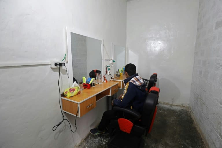 A boy sits in front of a mirror where he is learning hairdressing skills at the Hori rehabilitation centre on February 11, 2018