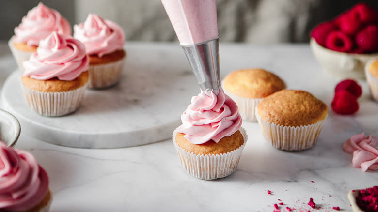 Hand decorating cupcakes with frosting