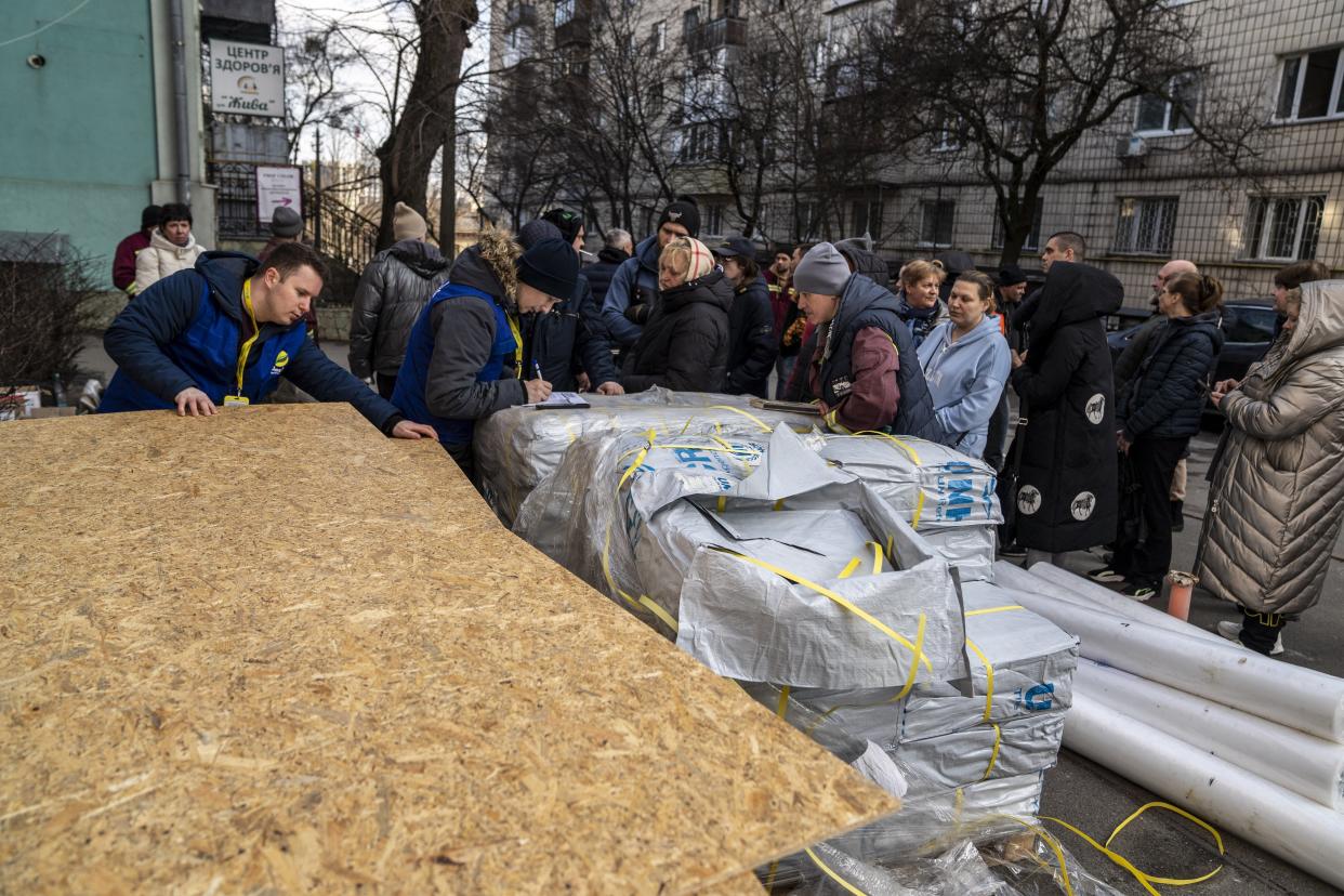 Residents wait near wreckages as several residential buildings are damaged following a Russian airstrike in Kyiv (Anadolu via Getty Images)