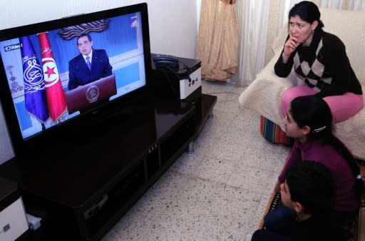 A Tunisian family watches TV on January 13, 2011 as Zine El-Abidine Ben Ali resigns as president