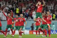 Morocco's Jawad El Yamiq, top, celebrates with team mates after the penalty shootout at the World Cup round of 16 soccer match between Morocco and Spain, at the Education City Stadium in Al Rayyan, Qatar, Tuesday, Dec. 6, 2022. (AP Photo/Luca Bruno)