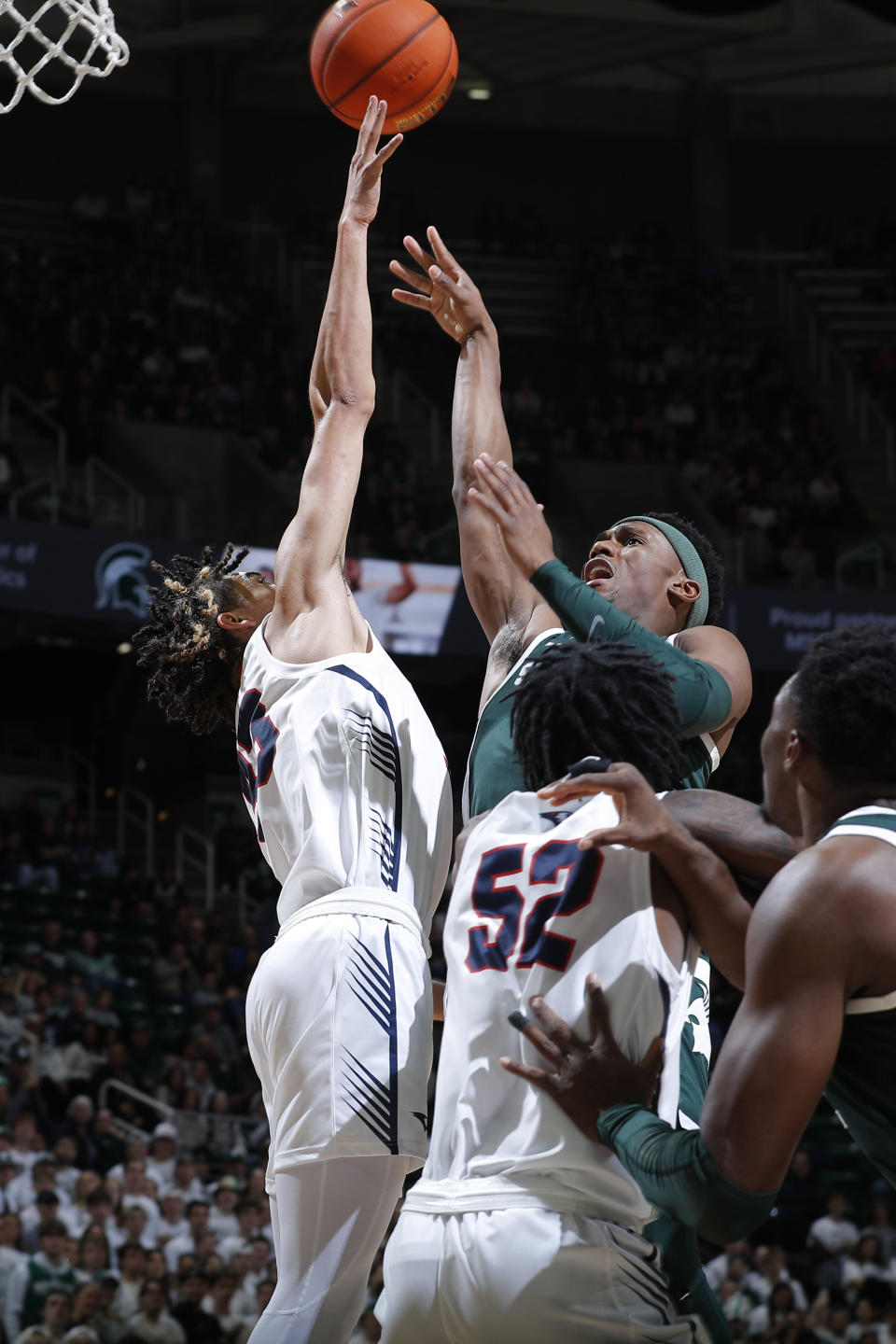 Michigan State's Tyson Walker, top right, shoots against Southern Indiana's Jeremiah Hernandez, left, and Kiyron Powell (52) during the second half of an NCAA college basketball game, Thursday, Nov. 9, 2023, in East Lansing, Mich. (AP Photo/Al Goldis)