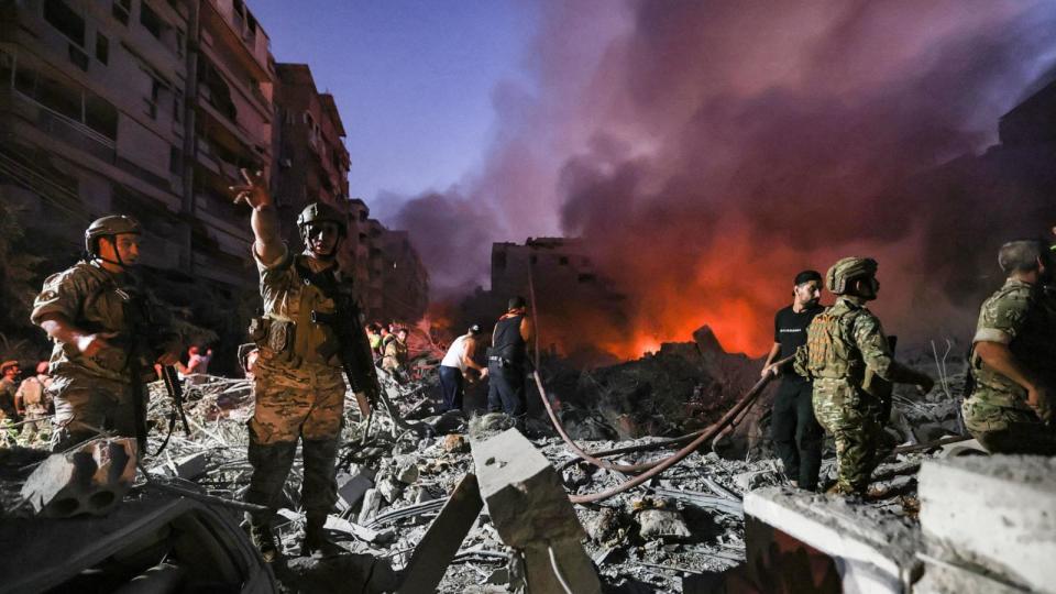 PHOTO: Lebanese army soldiers gather over the rubble of a levelled buildings as people flight the flames, following Israeli air strikes in the Haret Hreik neighborhood of Beirut's southern suburbs, Sept. 27, 2024.  (Ibrahim Amro/AFP via Getty Images)