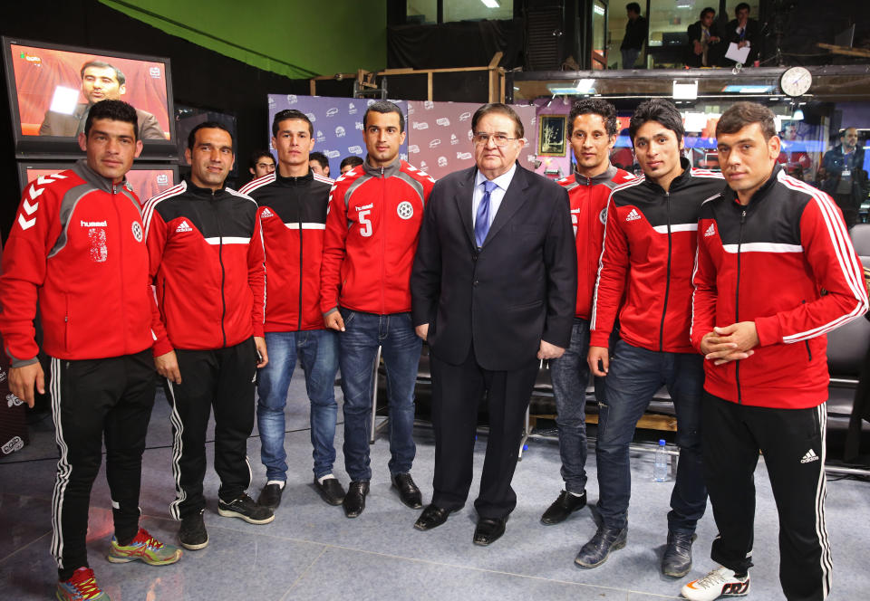 FILE - In this Tuesday, Feb. 4, 2014 file photo, Afghanistan presidential election candidate and former Defense Minister Abdul Rahim Wardak, center, poses for a photo along with Afghanistan national soccer team players after the first presidential election debate at the building of the Tolo TV, a private TV station, in Kabul, Afghanistan. Wardak, a longtime defense minister until he was removed by parliament in a vote of no confidence in 2012, gave no reason for his withdrawal and he was not throwing his support behind any remaining candidates, he said Sunday, March 16. (AP Photo/Massoud Hossaini, File)