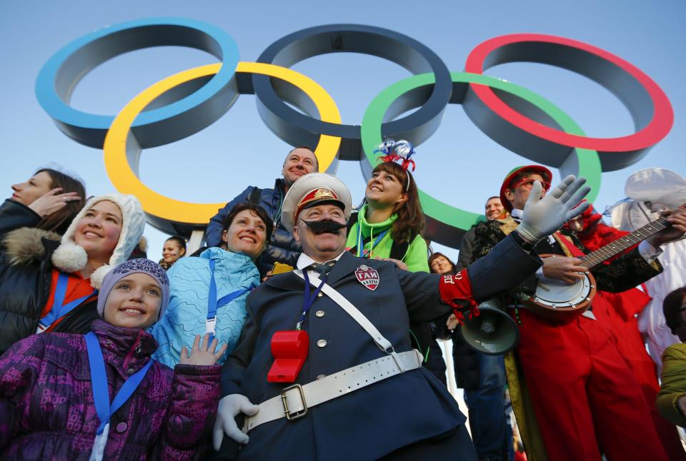 Fans cheer underneath the Olympic rings during the Sochi 2014 Winter Olympics February 8, 2014. REUTERS/Shamil Zhumatov (RUSSIA - Tags: SPORT OLYMPICS TPX IMAGES OF THE DAY) ATTENTION EDITORS: PICTURE 04 OF 22 FOR PACKAGE 'SOCHI - EDITOR'S CHOICE' TO FIND ALL IMAGES SEARCH 'EDITOR'S CHOICE - 08 FEBRUARY 2014'