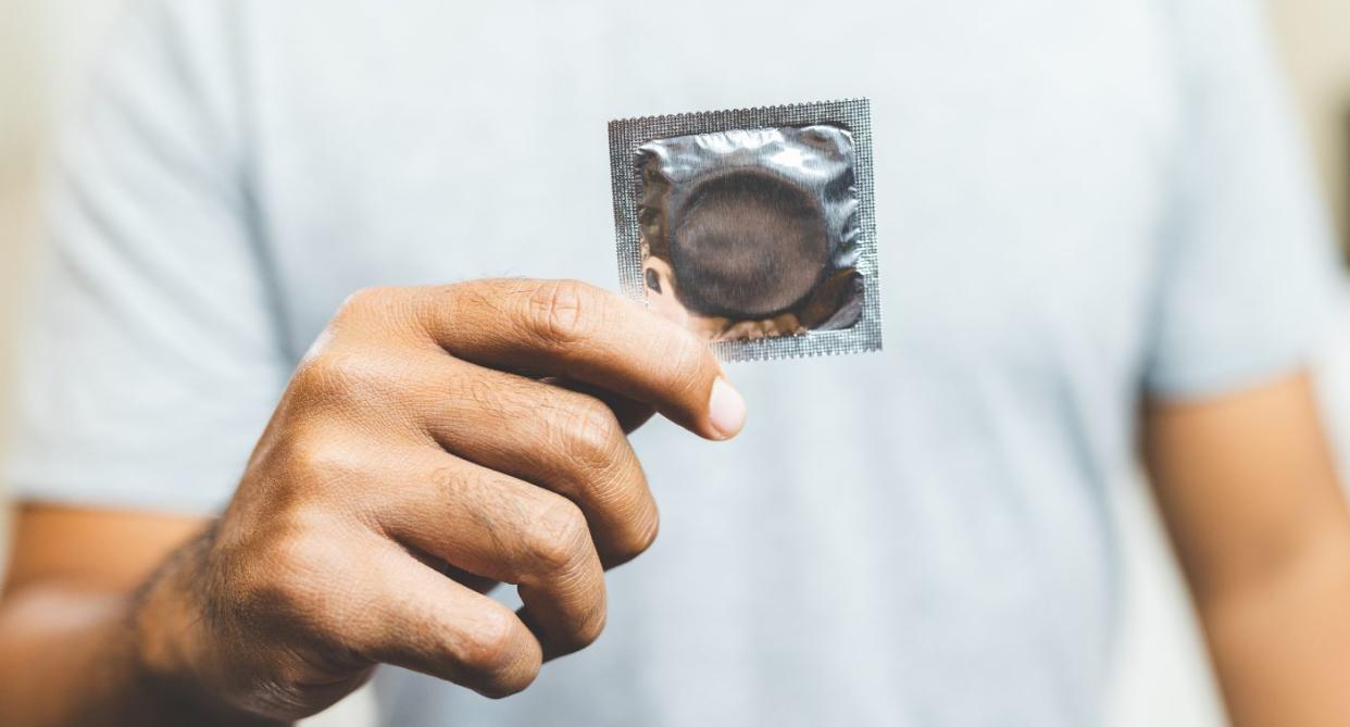 Man holding vegan condom. (Getty Images)