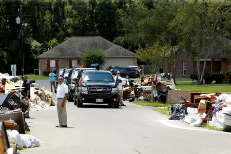 U.S. President Barack Obama's motorcade is seen nearby as he tours a flood-affected neighborhood in Zachary, Louisiana, U.S., August 23, 2016. REUTERS/Jonathan Ernst