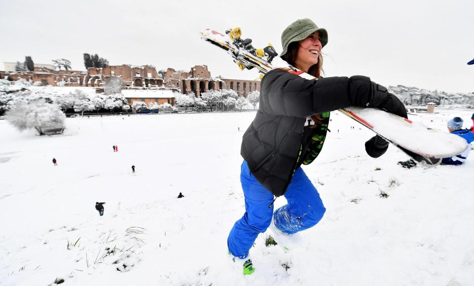 ROM03. ROMA (ITALIA), 26/02/2018.- Una chica carga con sus esquís tras disfrutar de la nieve en el Circo Massimo en Roma, Italia, hoy, 26 de febrero de 2018. La ola de frío siberiano, que han llamado Burian, llegó ayer a Italia provocando copiosas nevadas en el norte y un frío intenso que ha llegado hasta los 20 grados bajo cero en algunas localidades y hoy alcanzó el centro del país y Roma, donde los colegios permanecen cerrados. EFE/ ETTORE FERRARI