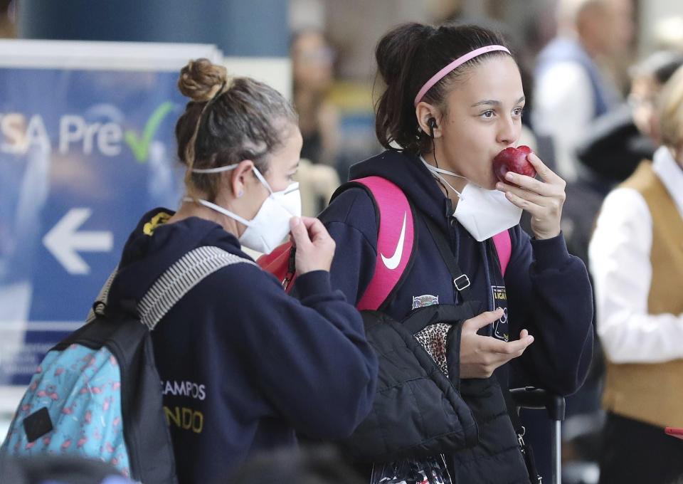 Airline passengers wear masks in the terminal area of Orlando International Airport on Wednesday, March 4, 2020. Many people are wearing masks in light of the Coronavirus outbreak.