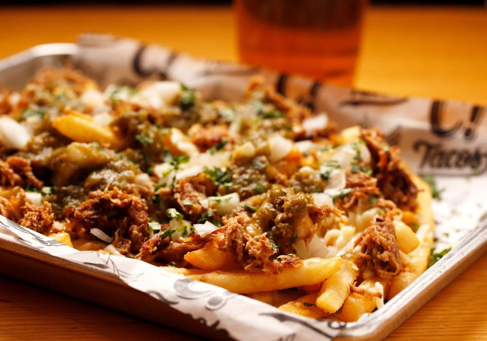 Capital Tacos' Ace High Carnitas is made with fried pork, green chiles, diced onions, and Chihuahua Cheese served over french fries.