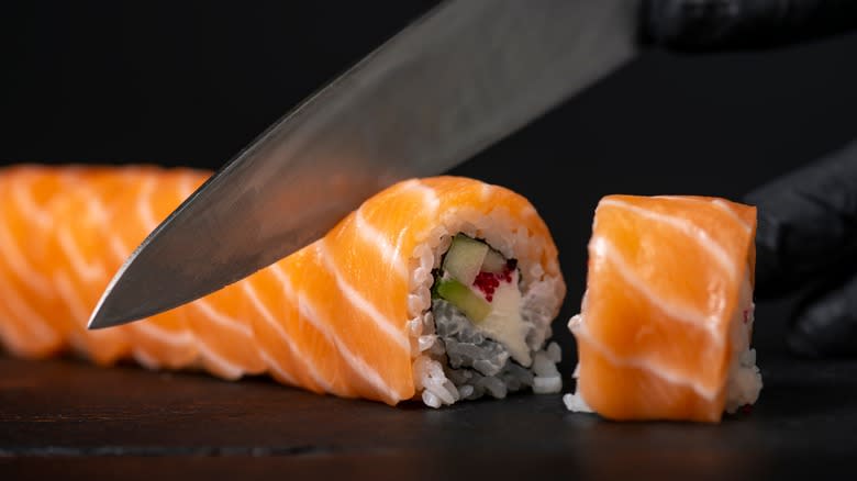 knife cutting sushi roll