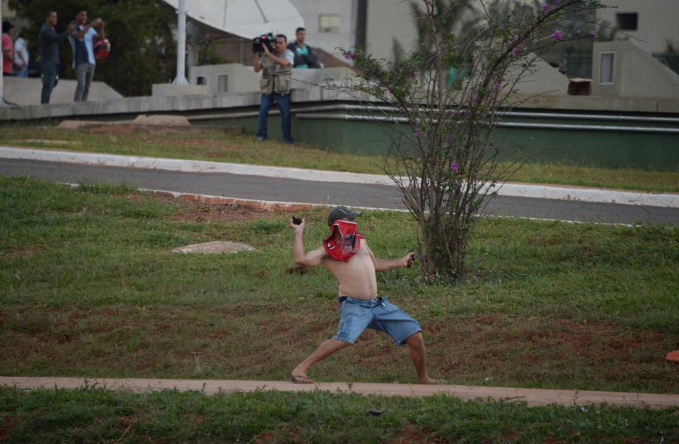 A demonstrator throws stones at riot policemen 