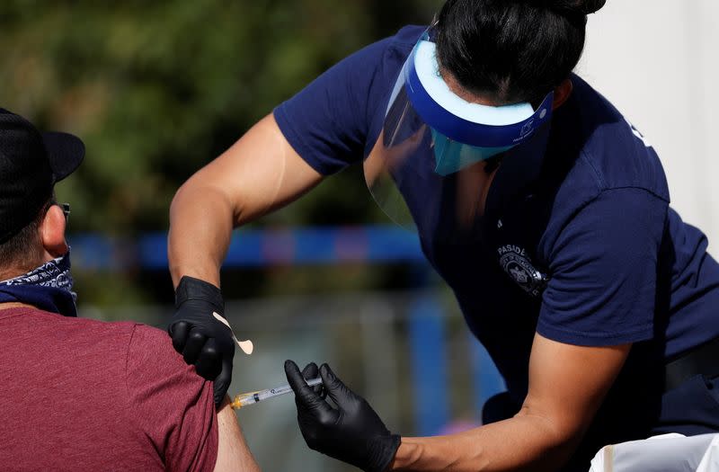 Firefighter Jenkins from Pasadena Fire Department administers a dose of the Moderna COVID-19 vaccine during the outbreak of the coronavirus disease (COVID-19), in Pasadena