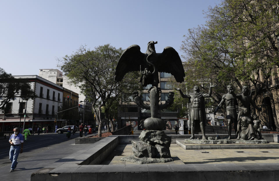 A man walks past statues representing the foundation of Tenochtitlan, the ancient capital of the Aztec empire in Mexico City, Tuesday, May 18, 2021. The capital of the Aztec empire, now known as Mexico City, fell after a prolonged siege 500 years ago, marking one of the few times an organized Indigenous army under local command fought European colonizers to a standstill for months, and the final defeat helped set the template for much of the conquest and colonization that came afterward. (AP Photo/Eduardo Verdugo)