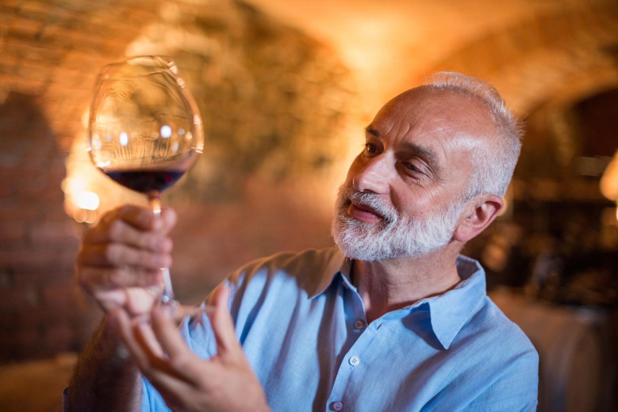 Family holidays in Langhe region, Piedmont, Italy: Man choosing and tasting wine