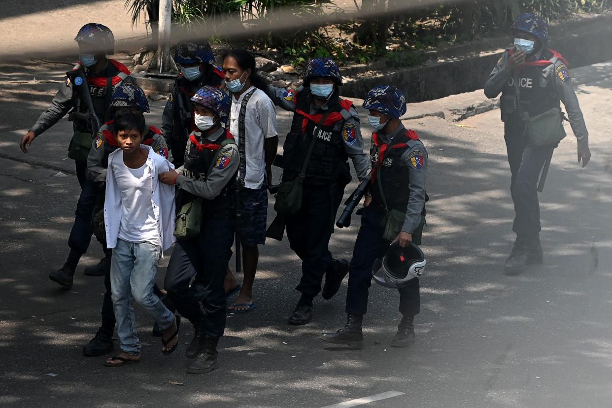 <p>Police arrest people in Yangon on 27 February as protesters demonstrate against country’s military coup</p> (AFP via Getty Images)