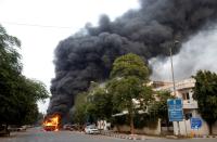 Smoke billows from a passenger bus after it was set on fire by demonstrators during a protest against a new citizenship law, in New Delhi