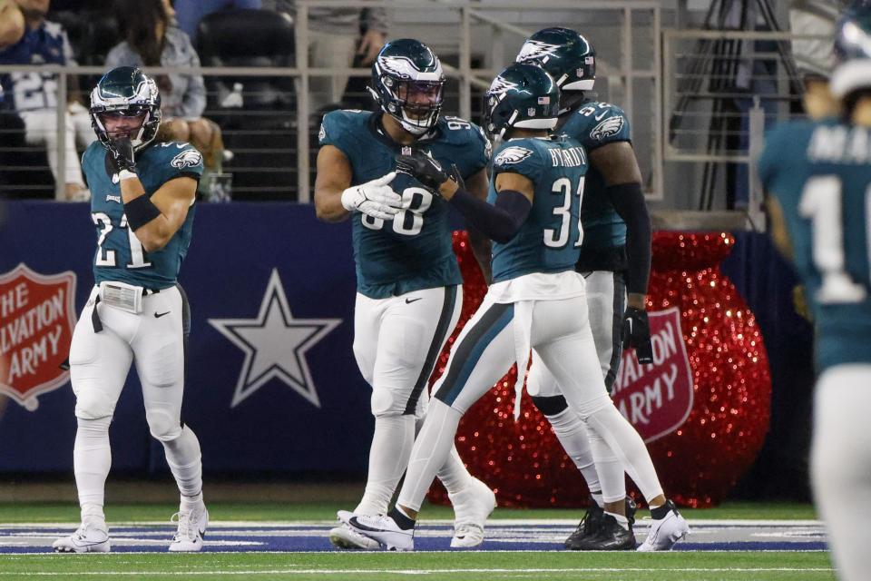 Philadelphia Eagles defensive tackle Jalen Carter, center, reacts with teammates Sydney Brown (21), Kevin Byard (31) and Zach Cunningham (52) after returning a Dallas Cowboys fumble for a touchdown during the second half of an NFL football game, Sunday, Dec. 10, 2023, in Arlington, Texas. (AP Photo/Michael Ainsworth)