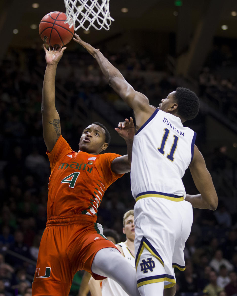 Miami's Keith Stone (4) goes up for a shot as Notre Dame's Juwan Durham (11) defends during the first half of an NCAA college basketball game Sunday, Feb. 23, 2020, in South Bend, Ind. (AP Photo/Robert Franklin)