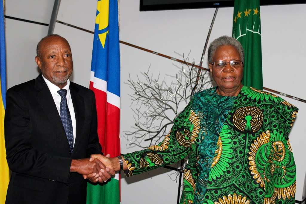 Newly sworn in Namibian acting president Nangolo Mbumba, left, shakes hands with Netumbo Nandi-Ndaitwa, his deputy, after taking the oath of office in the capital, Windhoek, Sunday, Feb, 4.2024.(AP Photo/Ester Mbathera)