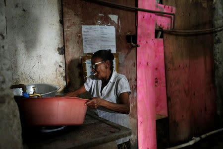 A woman washes dishes in a hallway of the abandoned Prestes Maia textile factory occupied by a homeless movement in downtown Sao Paulo, Brazil, May 7, 2018. REUTERS/Nacho Doce