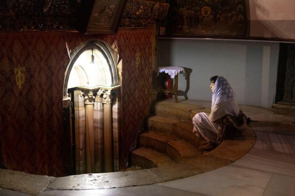 A worshiper prays next to grotto believed to be the spot where Jesus was born at Church of Nativity in Bethlehem