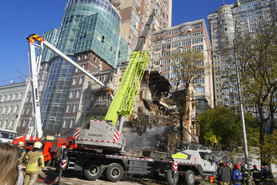 Firefighters work after a drone fired on buildings in Kyiv, Ukraine, Monday, Oct. 17, 2022. (AP Photo/Efrem Lukatsky)