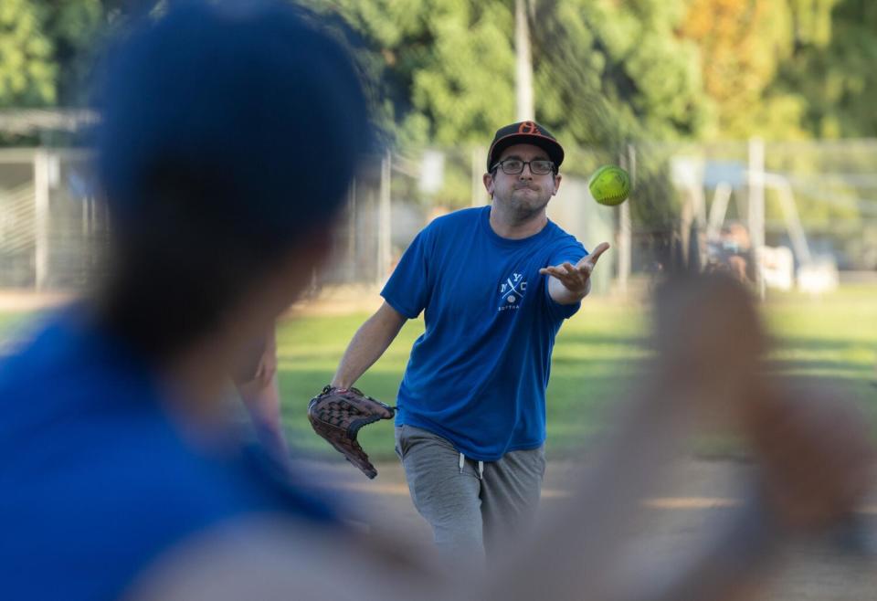 A person throws a sofball at another person.