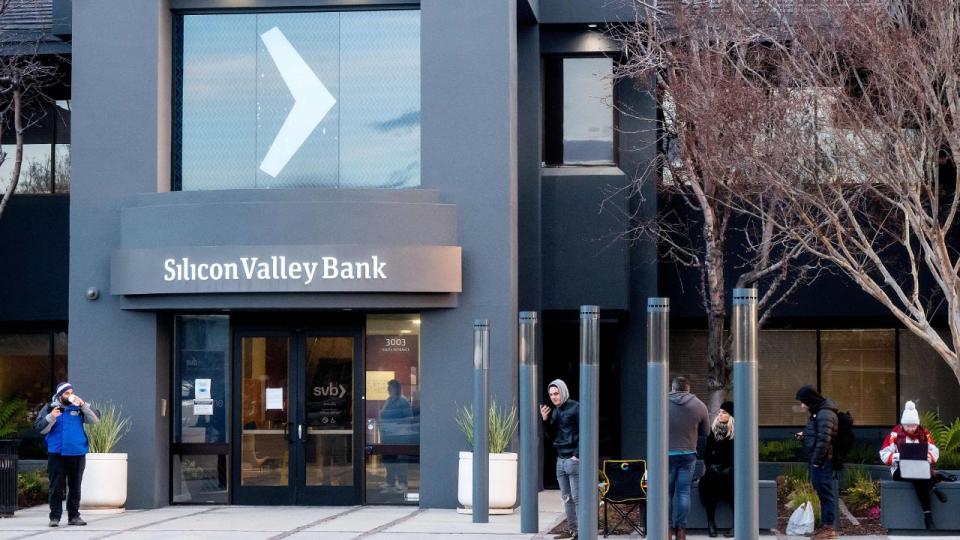 People waiting in the cold outside a bank