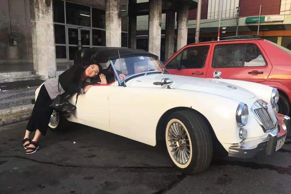 Lulu Yang poses with antique cars on a work trip to Cuba. (Courtesy Lulu Yang)