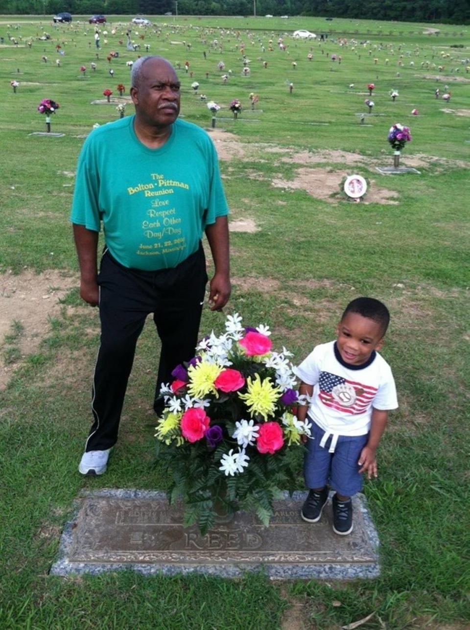 John Reed, left, stands next to the grave where his wife, Edith, and his second-born son, Carlos, rest in peace.