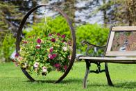 <p>This stunning spherical display was created by cleverly mounting a hook for a hanging planter inside an antique steel wagon wheel.</p>