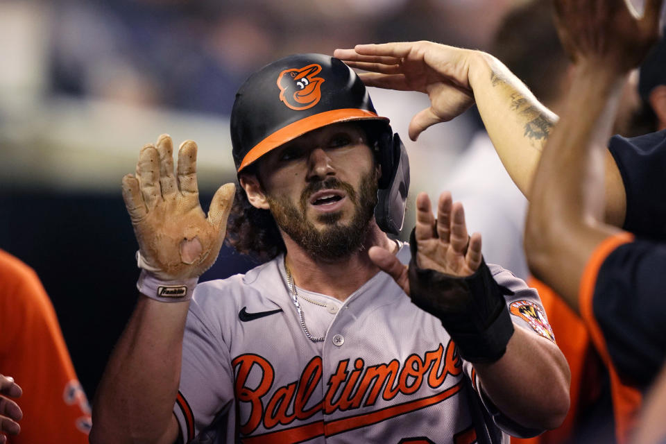 Baltimore Orioles' Ryan McKenna is greeted in the dugout after scoring from third on a throwing error by Detroit Tigers left fielder Akil Baddoo during the seventh inning of a baseball game against the Detroit Tigers, Thursday, July 29, 2021, in Detroit. (AP Photo/Carlos Osorio)