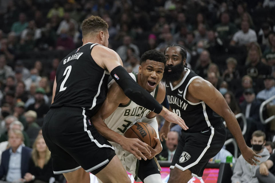 Milwaukee Bucks' Giannis Antetokounmpo goes to the basket against Brooklyn Nets' Blake Griffin (2) and James Harden (13) during the first half of an NBA basketball game Tuesday, Oct. 19, 2021, in Milwaukee. (AP Photo/Morry Gash)