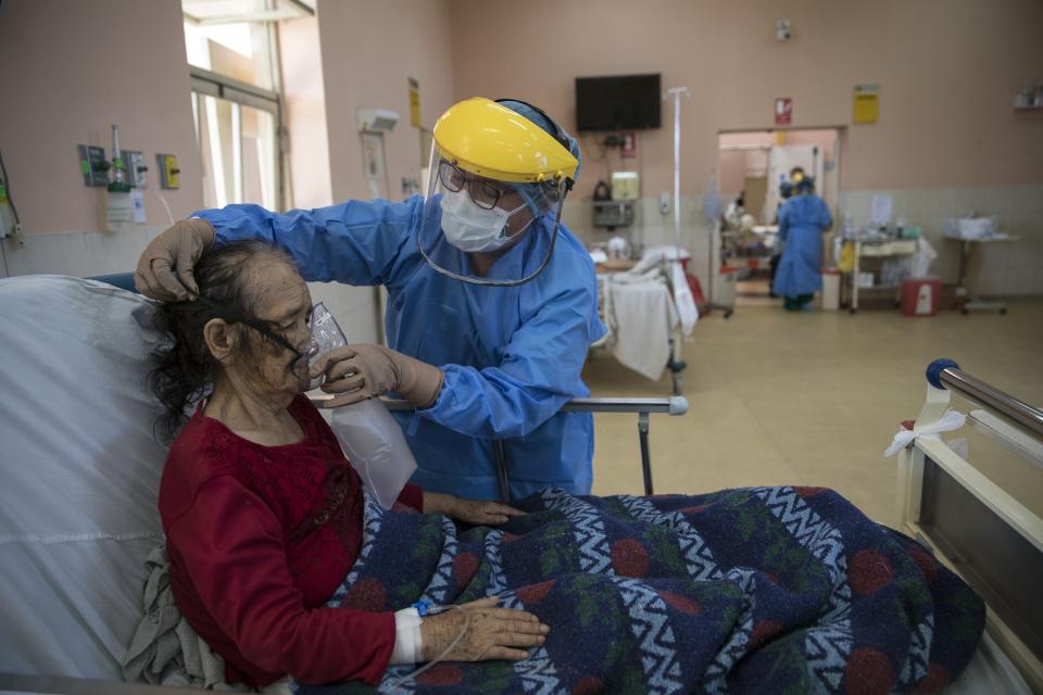 A nurse places an oxygen mask on a patient inside the intensive care unit for people infected with the new coronavirus, at the 2 de Mayo Hospital, in Lima, Peru, Friday, April 17, 2020. The new coronavirus causes mild or moderate symptoms for most people, but for some, especially older adults and people with existing health problems, it can cause more severe illness or death. (AP Photo/Rodrigo Abd)