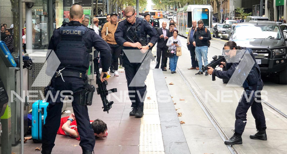 Heavily armed officers can be seen arresting the man accused of threatening commuters on a Melbourne tram. Source: Ken Abrahams