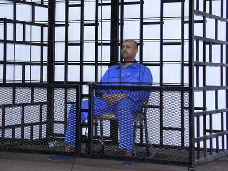 Saif al-Islam Gaddafi, son of late Libyan leader Muammar Gaddafi, attends a hearing behind bars in a courtroom in Zintan May 25, 2014. REUTERS/Stringer