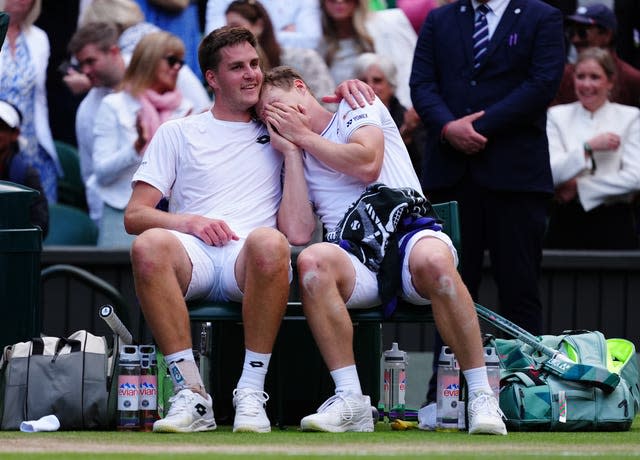 Henry Patten puts an arm around Harri Heliovaara, who is covering his face 