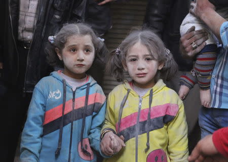 Girls who survived what activists said was a ground-to-ground missile attack by forces of Syria's President Bashar al-Assad, hold hands at Aleppo's Bab al-Hadeed district April 7, 2015. REUTERS/Abdalrhman Ismail/Files