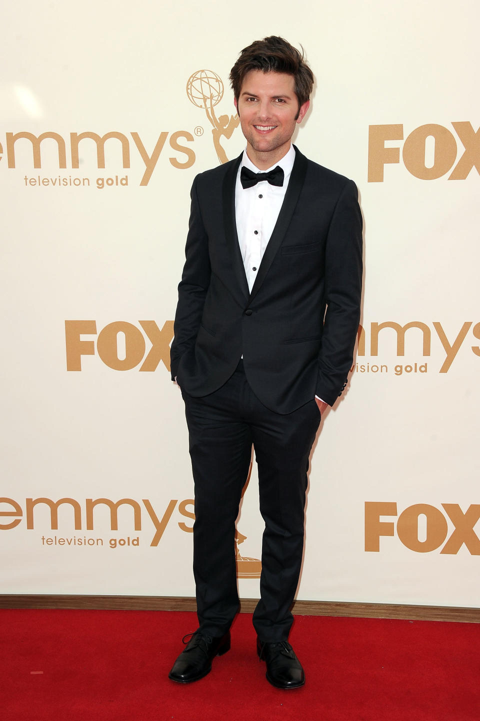 Adam Scott smiling on the red carpet in a tux