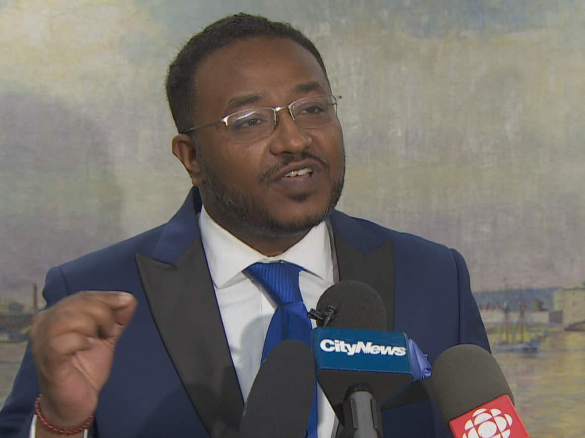 Walied Khogali Ali, of the Regent Park Neighbourhood Association, was part of a coalition of housing advocates at city hall on Thursday. They are calling on a group of developers to drop an appeal against a key part of the city's planning act that helps determine housing affordability.  (CBC - image credit)