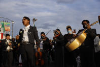 A mariachi band sings in front of the demonstrators as they take part in a peace walk honoring the life of police shooting victim 13-year-old Adam Toledo, Sunday, April 18, 2021, in Chicago's Little Village neighborhood. (AP Photo/Shafkat Anowar)