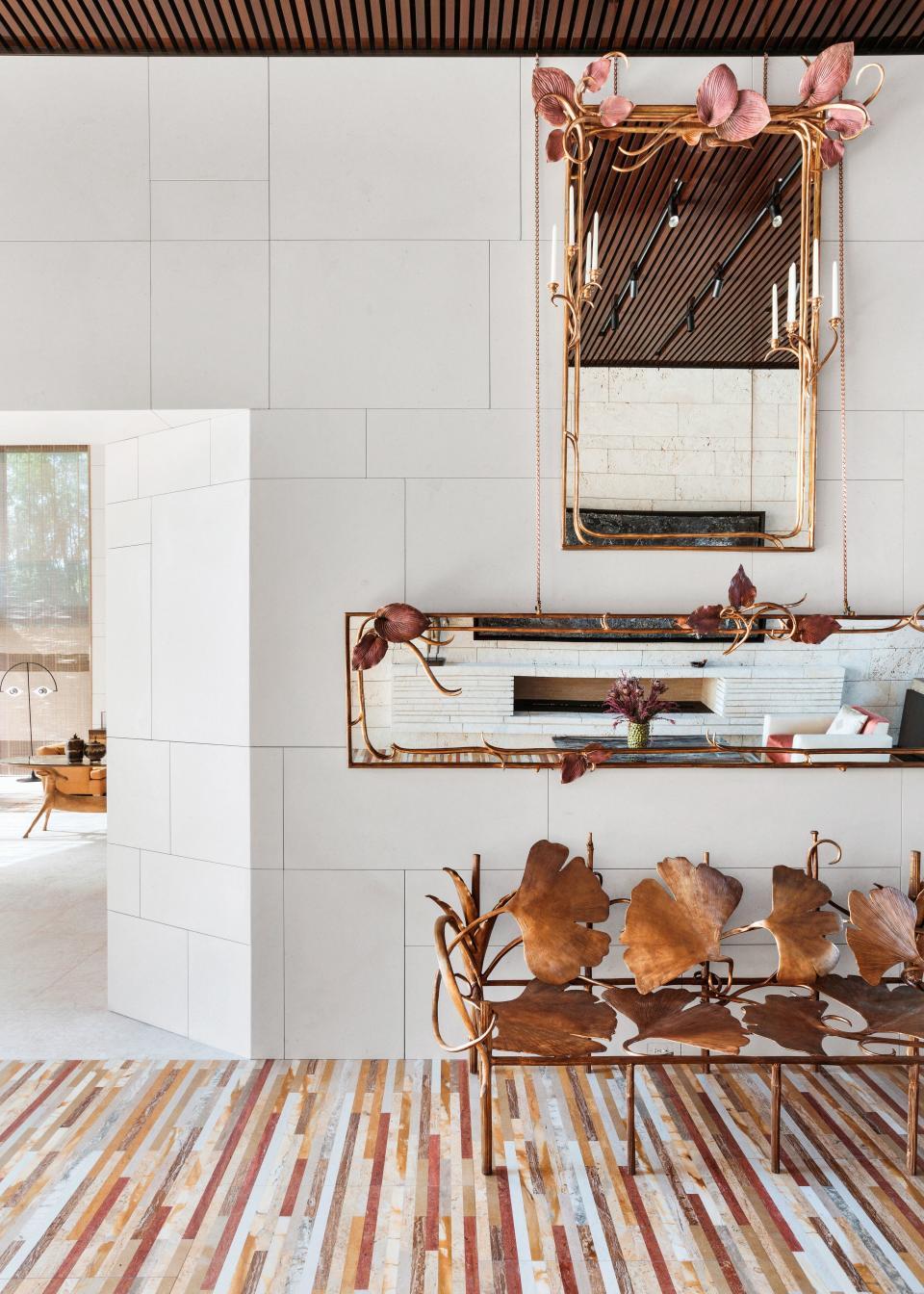 Mirrors and ginkgo bench, all by Claude Lalanne, line the gallery. On the floor, Marino created a “carpet” of a variety of marble and travertine strips.