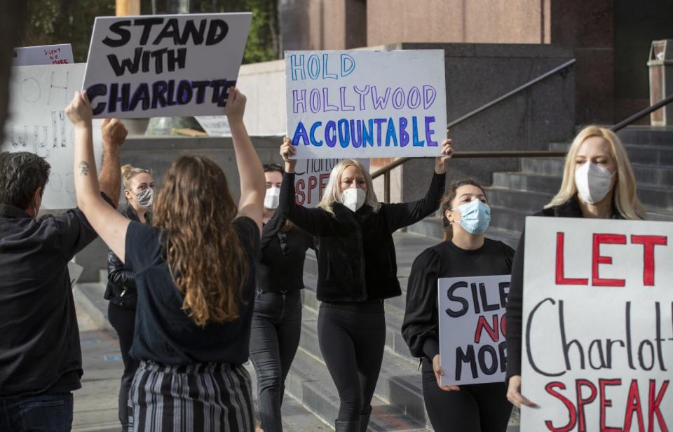 Protesters hold signs in support of Charlotte Kirk