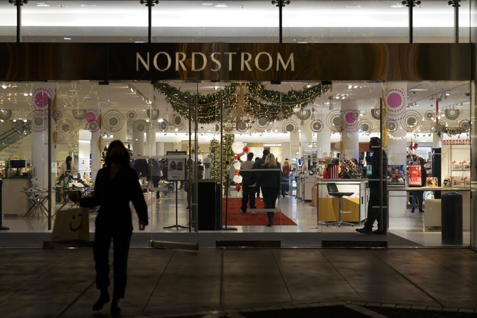 FILE - A security guard, right, stands at the entrance to a Nordstrom department store at the Grove mall in Los Angeles, Thursday, Dec. 2, 2021, where a recent smash-and-grab robbery took place. Responding to the recent mass of smash-and-grab thefts in the state, Democratic Assemblywoman Jacqui Irwin is proposing legislation to make it easer for district attorneys to prosecute organized retails thefts that cross county lines. (AP Photo/Jae C. Hong, File)