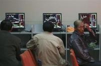 Investors sit in front of computer screens at a brokerage house in Shenyang, Liaoning province, May 12, 2014. China's main stock index closed at its best level in two-and-a-half weeks on Monday, underpinned by Beijing's pledge to push ahead with a broad range of capital market reforms and a surging commodities sector. REUTERS/Stringer