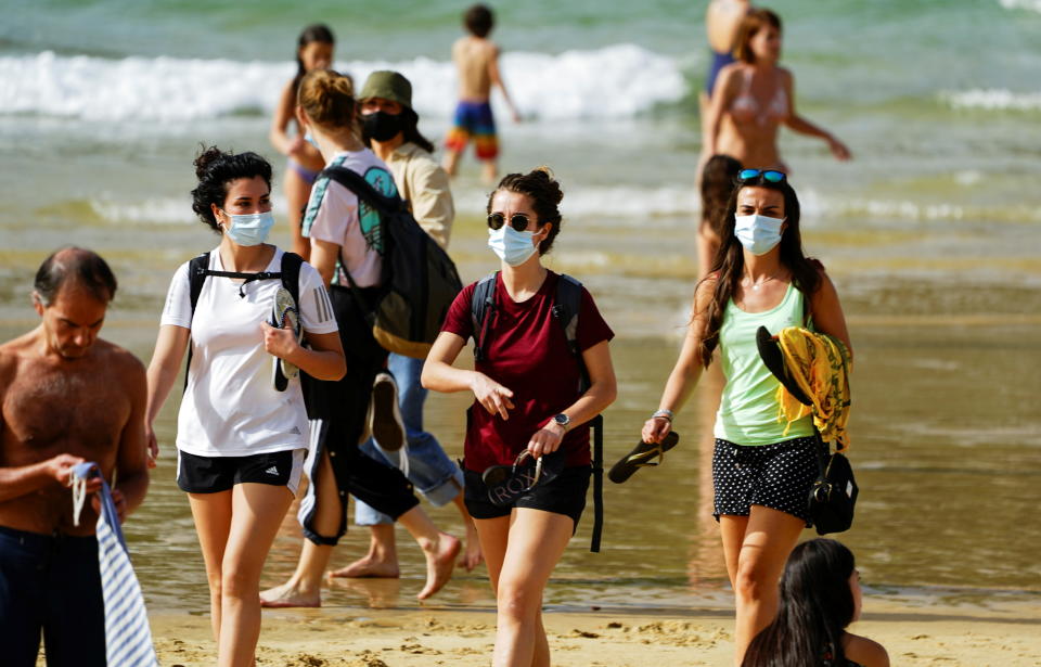 People wear masks at La Concha beach after Spain introduced stricter mask laws during the coronavirus disease (COVID-19) outbreak, in San Sebastian, Spain, March 31, 2021. REUTERS/Vincent West