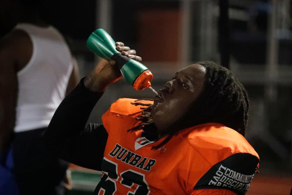 Dunbar High School football player Xavion  Holmes takes a water break during game action Tuesday, October 18, 2022. Dunbar hosted Cypress Lake for a regular season football matchup. The game had been re-scheduled after the impact of Hurricane Ian forced schools to postpone activities. 