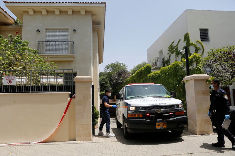 An Israeli policeman stands nearby as an ambulance leaves the residence of China's ambassador to Israel, Du Wei, in Herzliya, near Tel Aviv, Israel